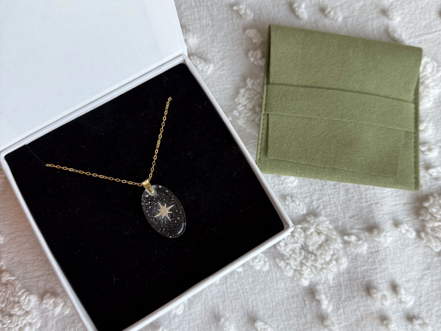 A memorial pendant  with the ashes in the shape of a star seated in a velvet lined jewelry box
