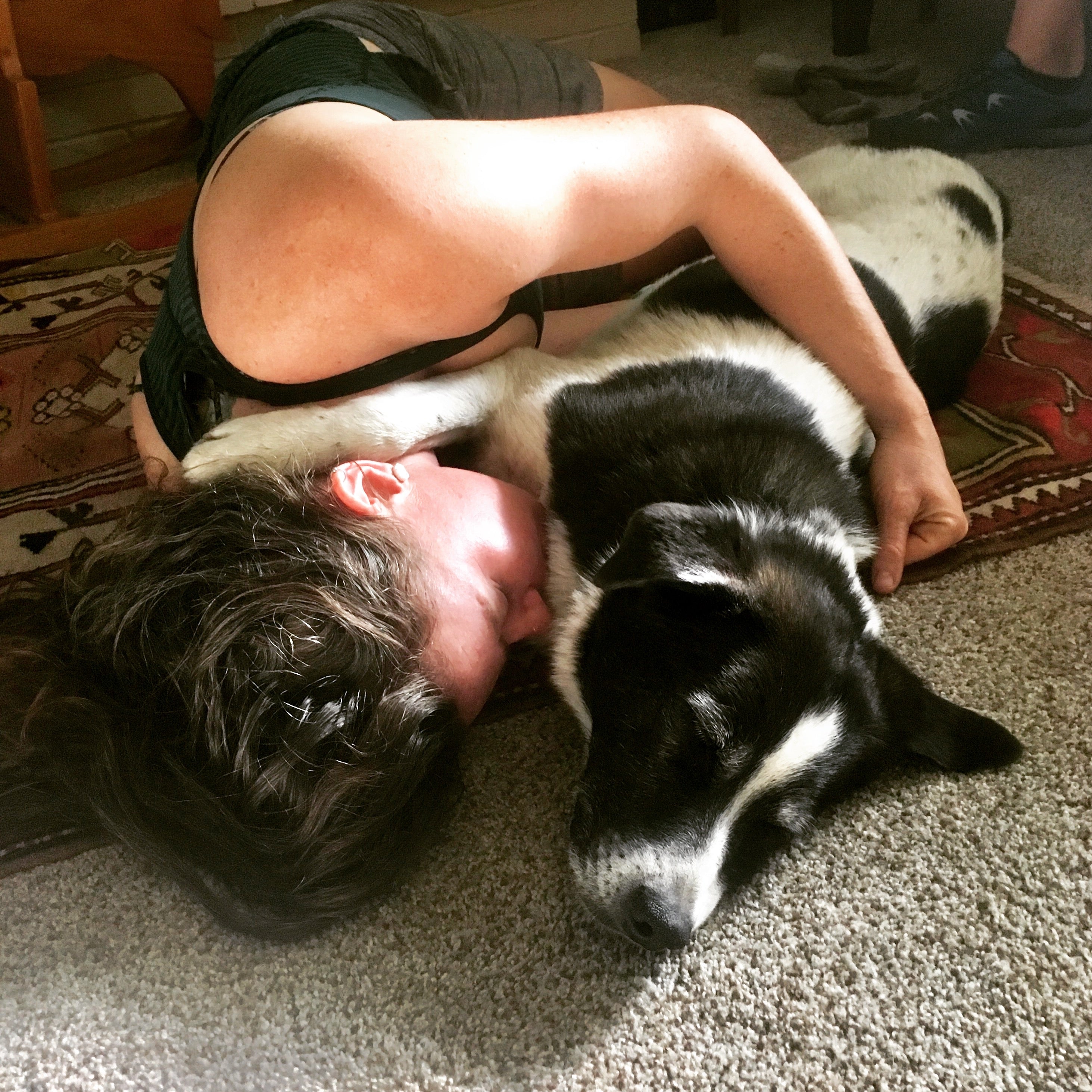 A woman snuggling her dog who sent in the dogs ashes for a star memorial glass pendant